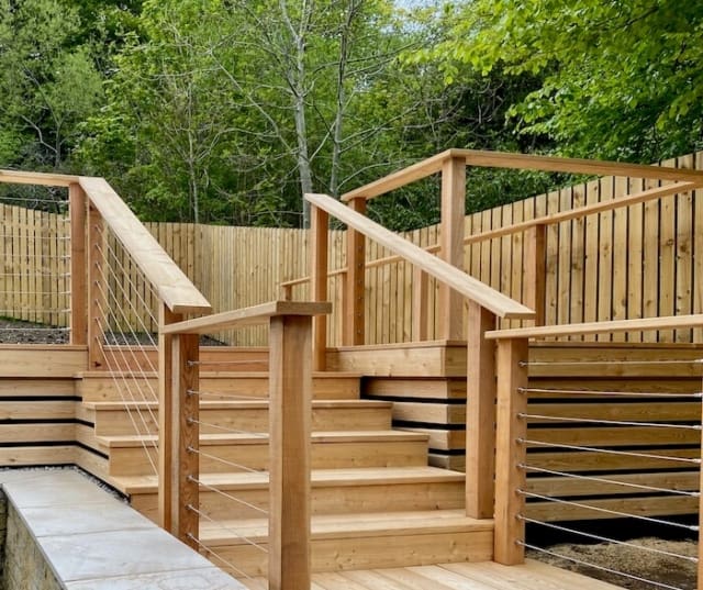 Larch deck steps with handrails and balustrades lead to a dining deck