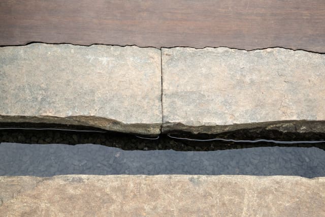 Craftsmanship in scribing bamboo deck around natural stone reclaimed kerbs